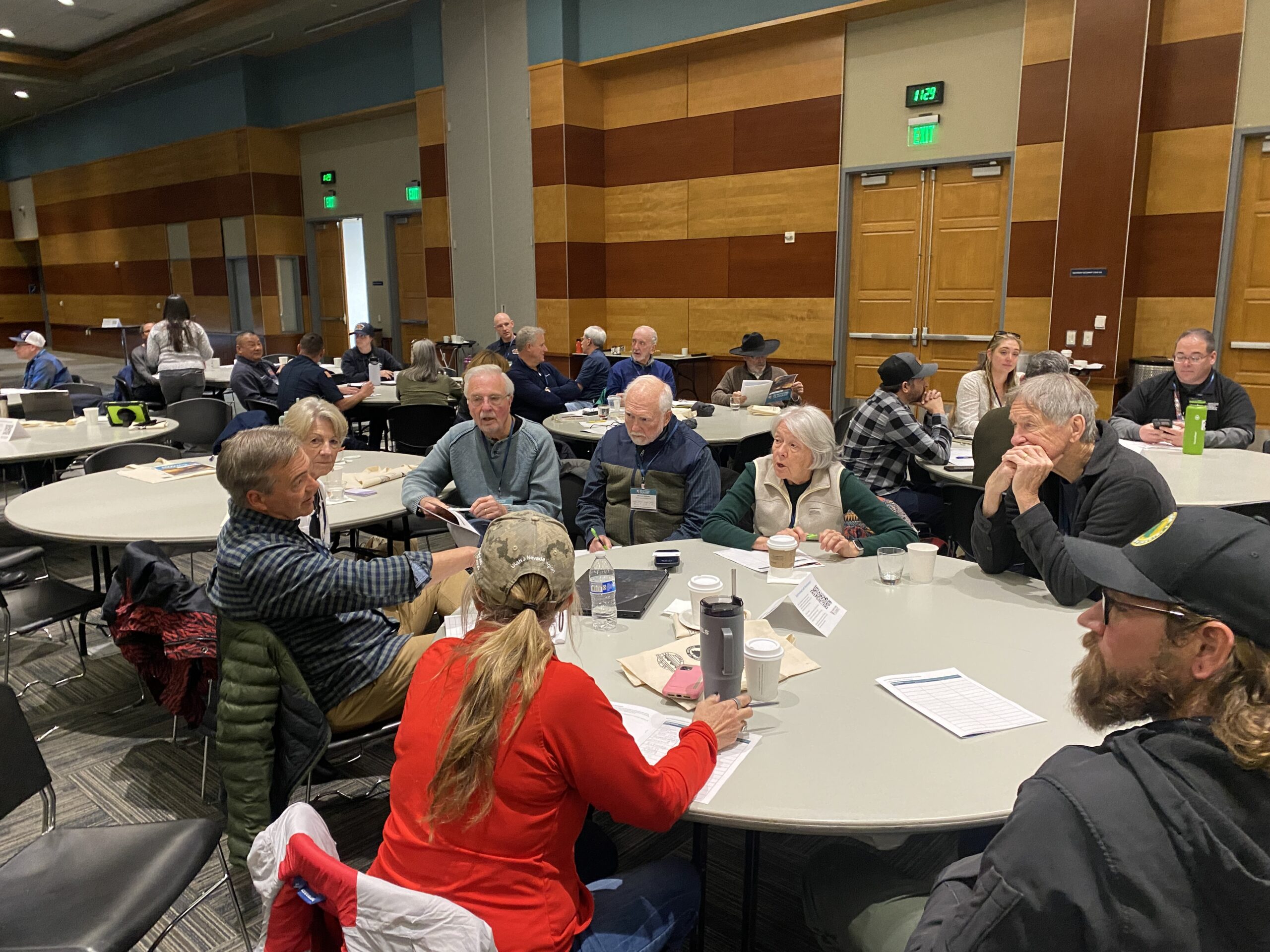 A group of event attendees talking while seated at tables