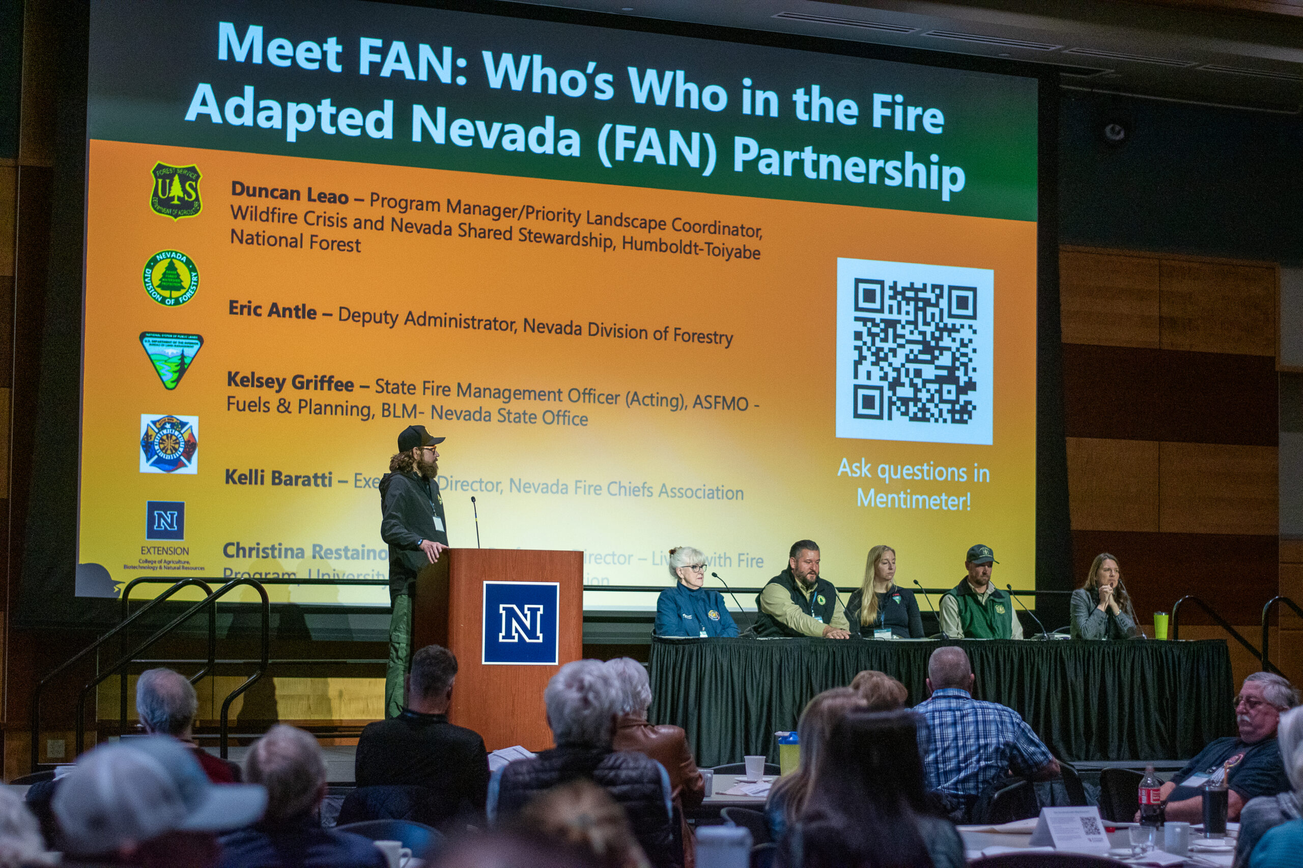 A group of panelists on a stage in front of an audience