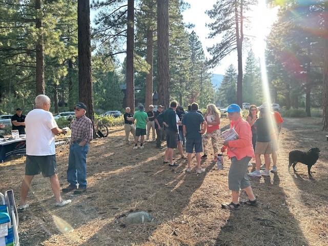 A group of people gathered outdoors in a forested area